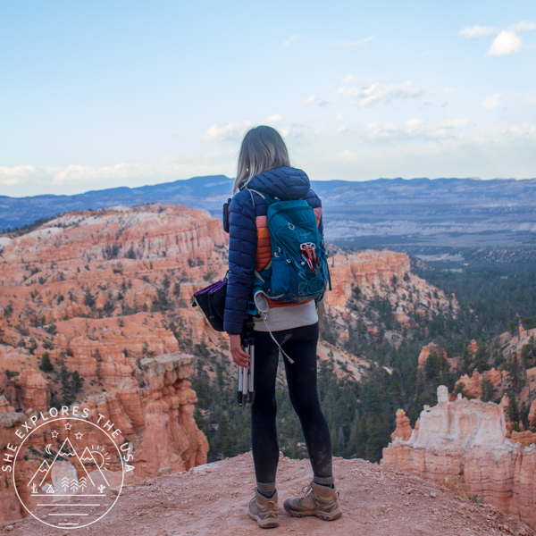 a woman overlooking Bryce Canyon is wearing an Osprey backpack