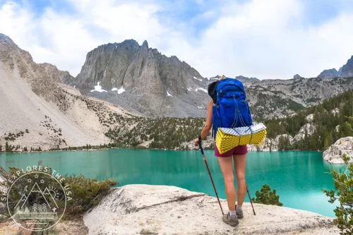 A woman backpacker admires the beauty of Big Pine Lakes