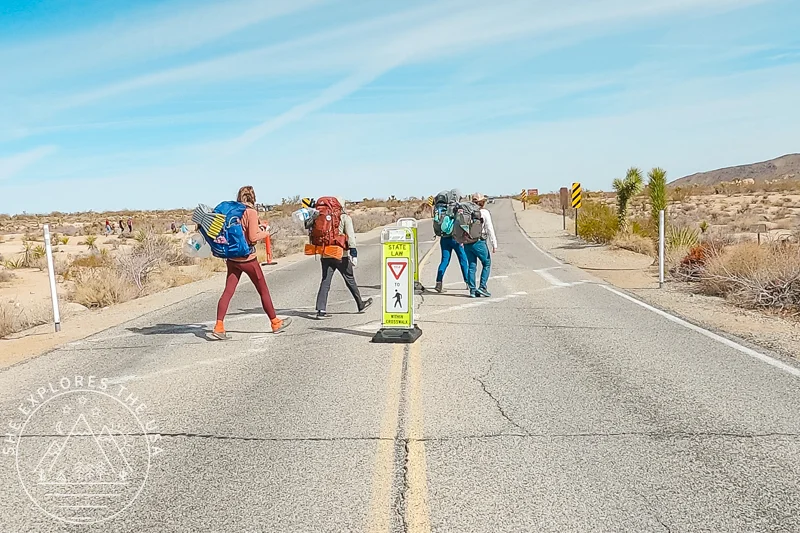 backpackers crossing the road at Twin Tanks