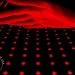 Astarexin Red Light Therapy Pad turned on with a hand over it lit up in red