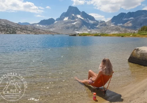 Patagonia Summer Sale 2025 - a female hiker sits in her REI flexlite air chair in thousand island lake in the Sierra