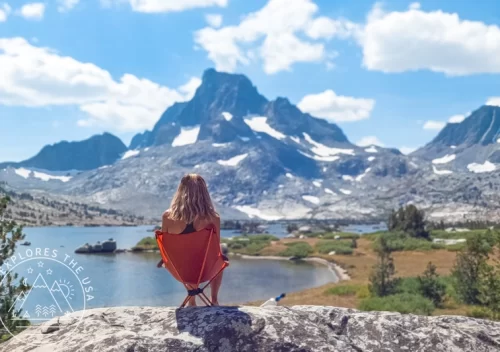 Relaxing in a backpacking chair with scenic mountain view, highlighting back comfort and lumbar support routine.