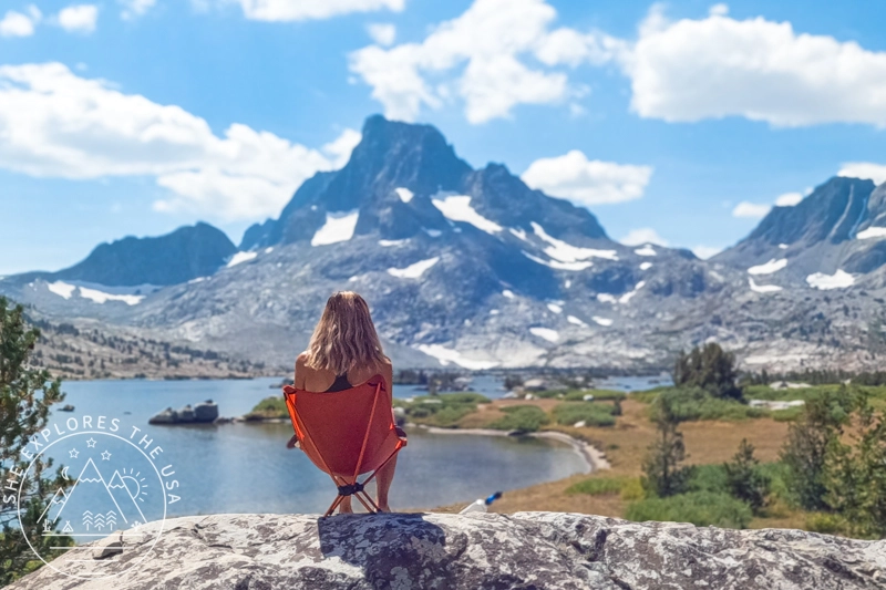 Relaxing in a backpacking chair with scenic mountain view, highlighting back comfort and lumbar support routine.