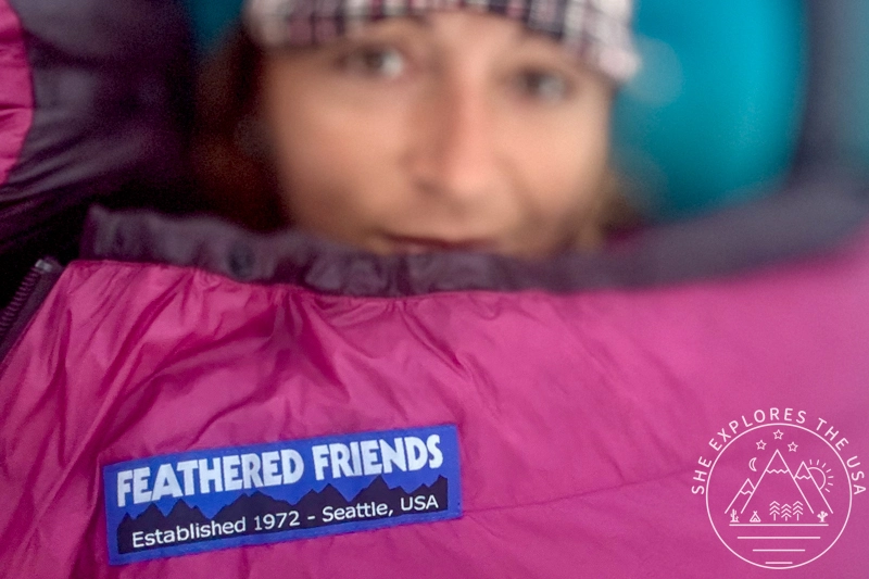 A woman is seen insider her Feathered Friends petrel 10 ul sleeping bag