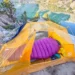 Feathered Friends Petrel UL 10 sleeping bag inside a tent overlooking an alpine lake during a backcountry camping trip.