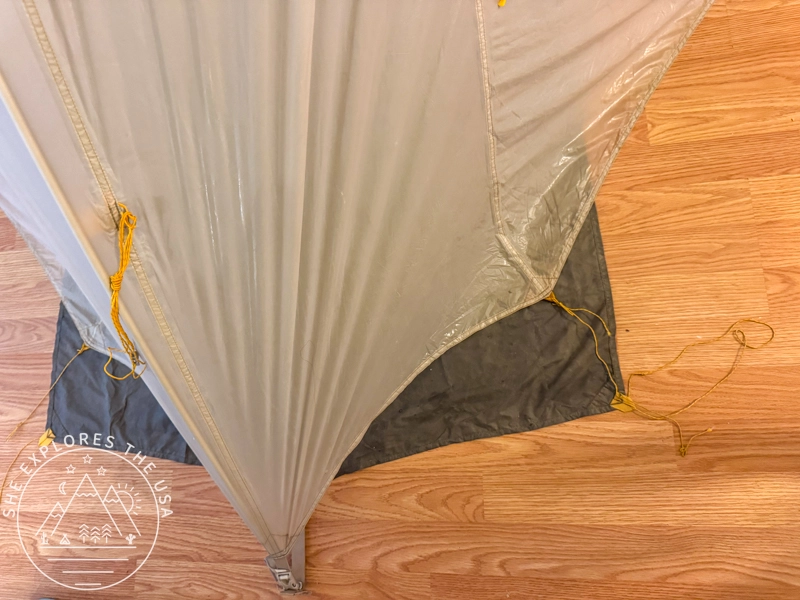 Big Agnes tent footprint and rainfly set up indoors on a hardwood floor for maintenance