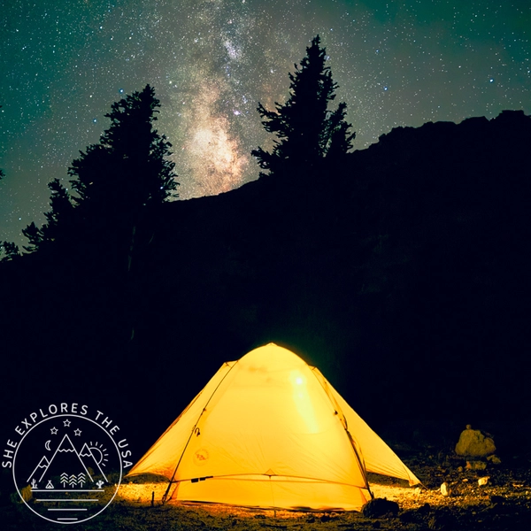 Glow of a tent at night under a starry sky and Milky Way after rainfly restoration