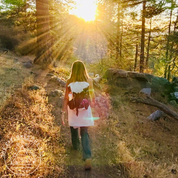 ariel view of a woman hiking using the HoverAir X1 Pro with a sunstar ahead and in follow mode